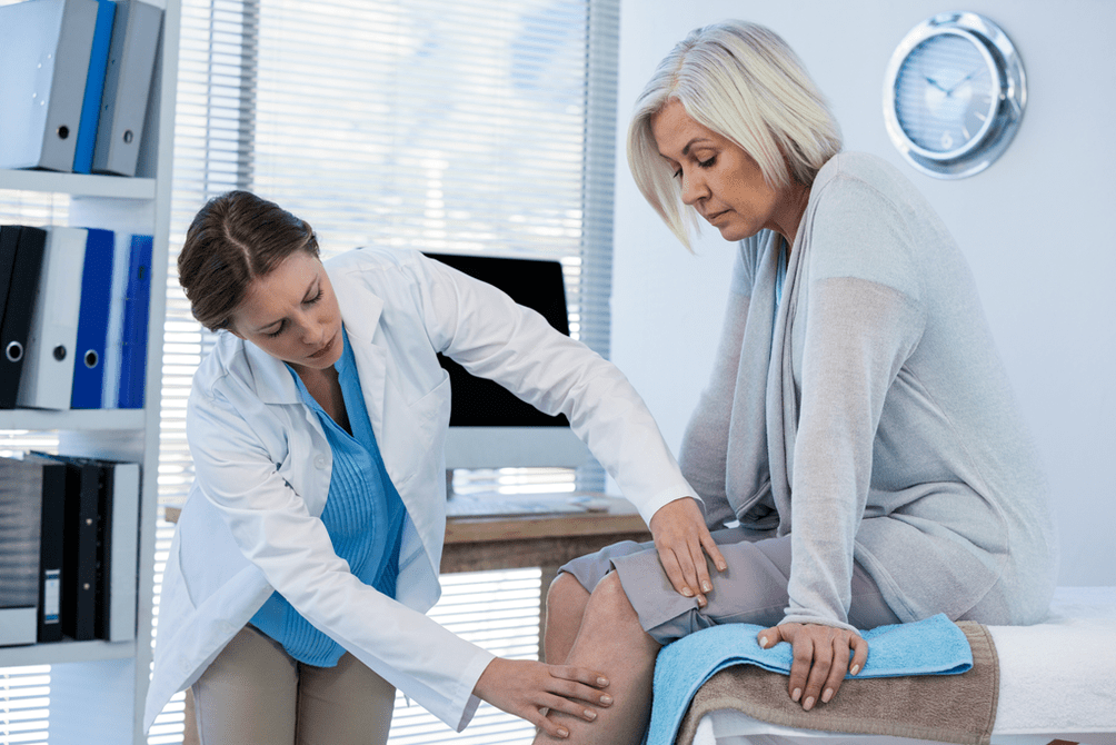 Um paciente com artrose que precisa de terapia sendo examinado por um médico